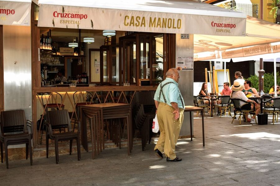Seville: Tapas, Taverns, and History Walking Tour - Stop 1: An early-1900s tavern and flaming chorizo with barrel vermouth